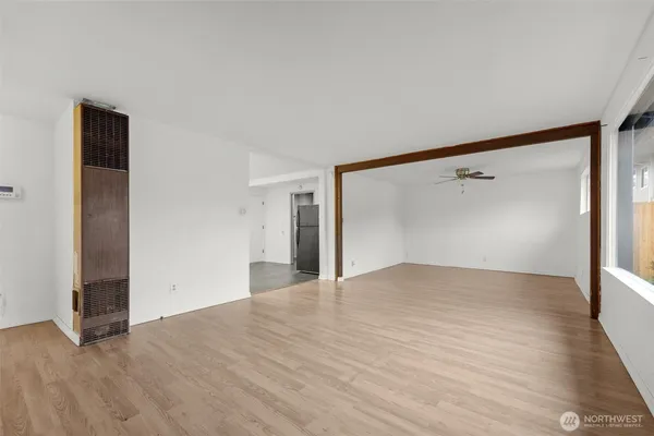 an empty room with a window and a ceiling fan