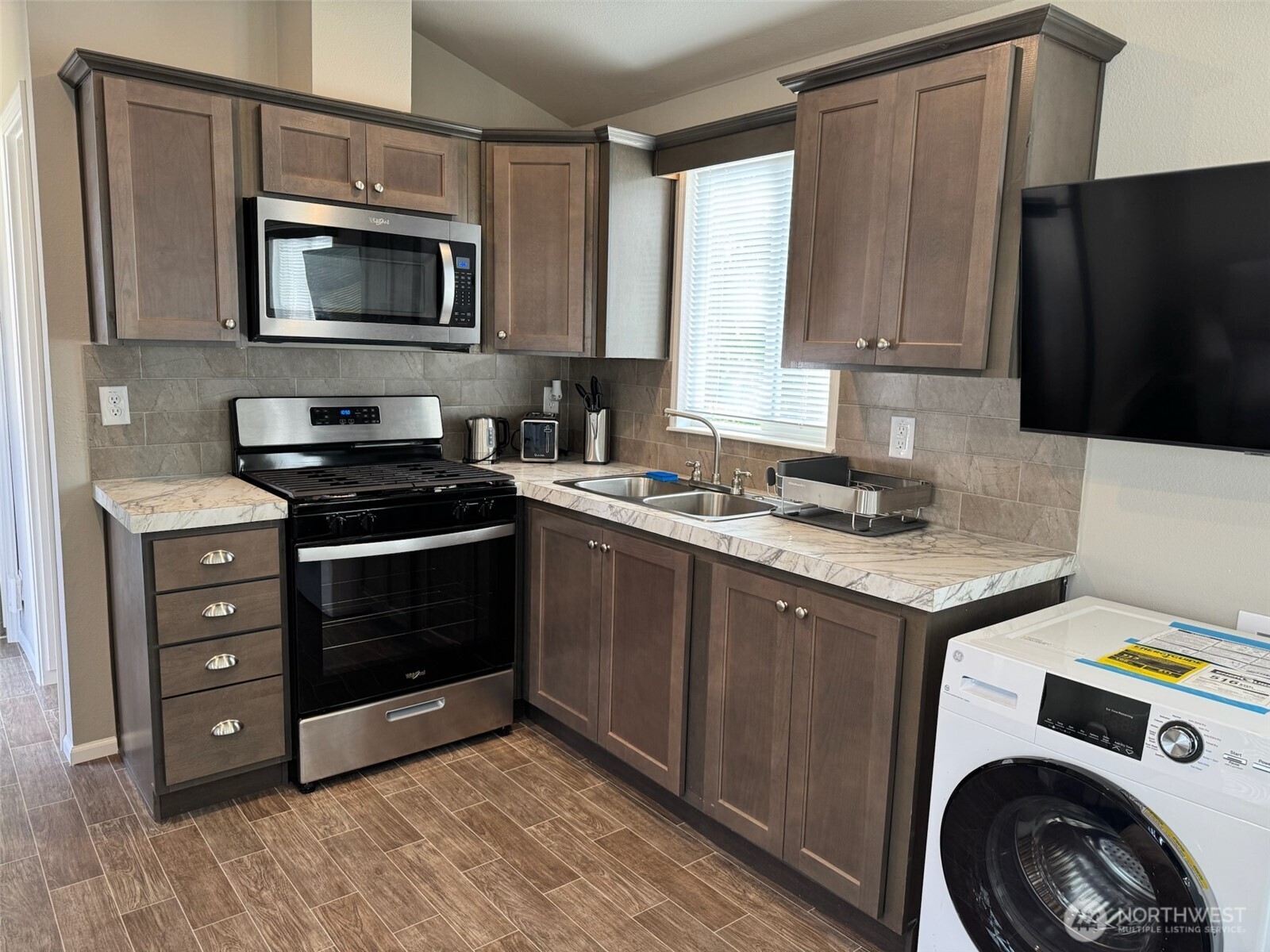 545 Hendricks Street, Unit 10A Port Townsend, WA 98368 - Photo 6 of 17 a kitchen with granite countertop a stove and a microwave