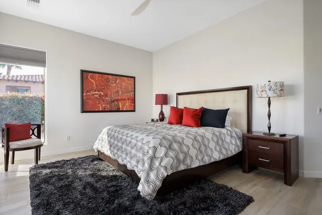 a bedroom with a bed and a dresser next to a window