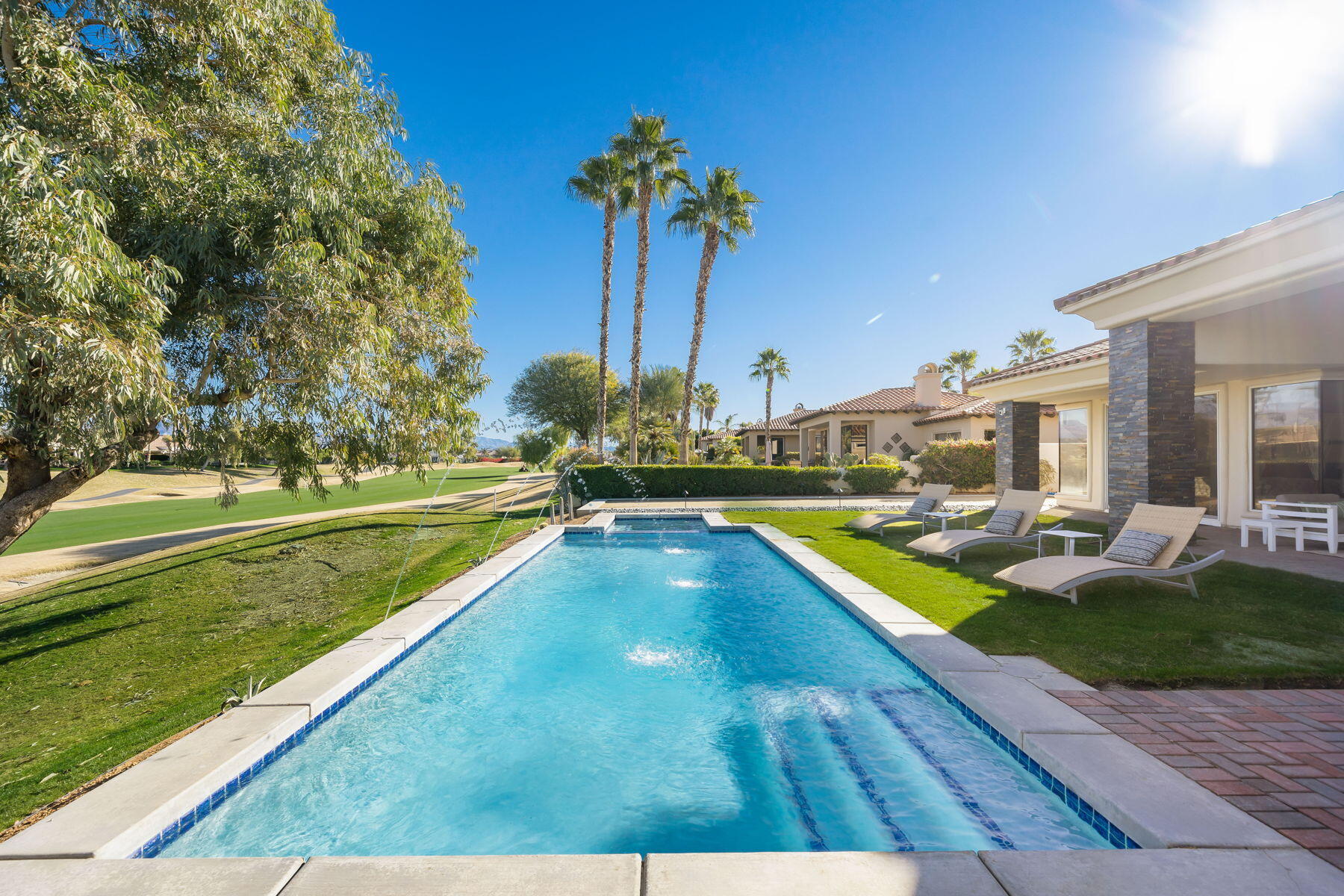 253 Loch Lomond Road Rancho Mirage, CA 92270 - Photo 57 of 66 a view of a swimming pool with a yard and palm trees