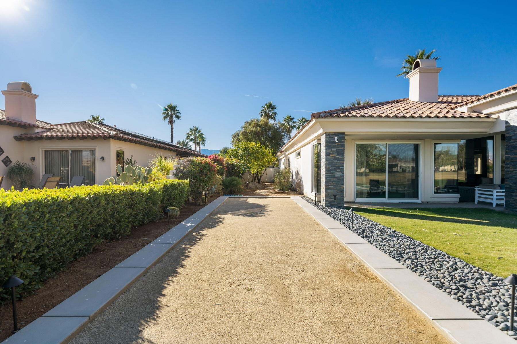 253 Loch Lomond Road Rancho Mirage, CA 92270 - Photo 60 of 66 a front view of a house with a yard and potted plants