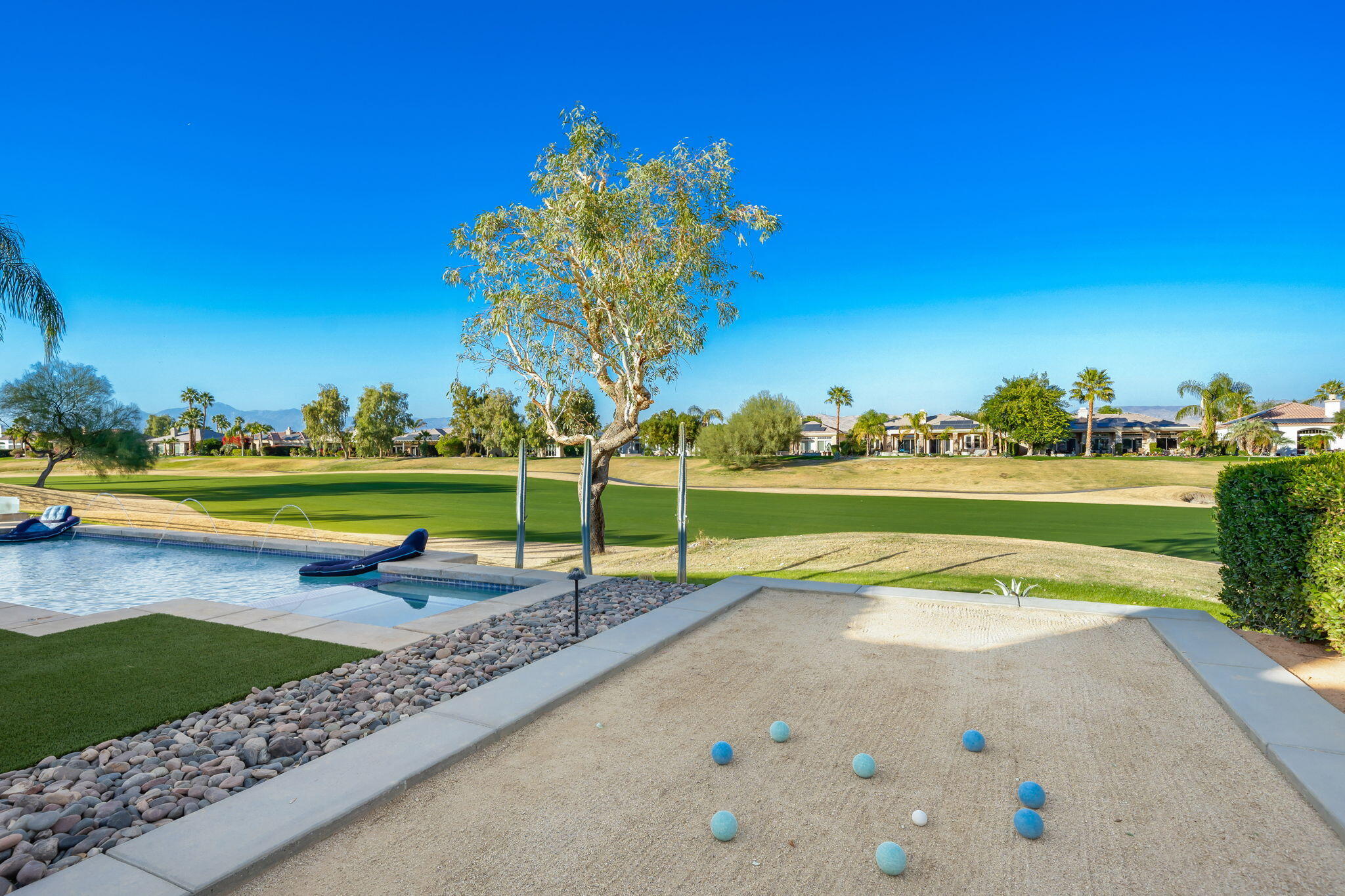 253 Loch Lomond Road Rancho Mirage, CA 92270 - Photo 62 of 66 a view of a swimming pool with a garden and trees