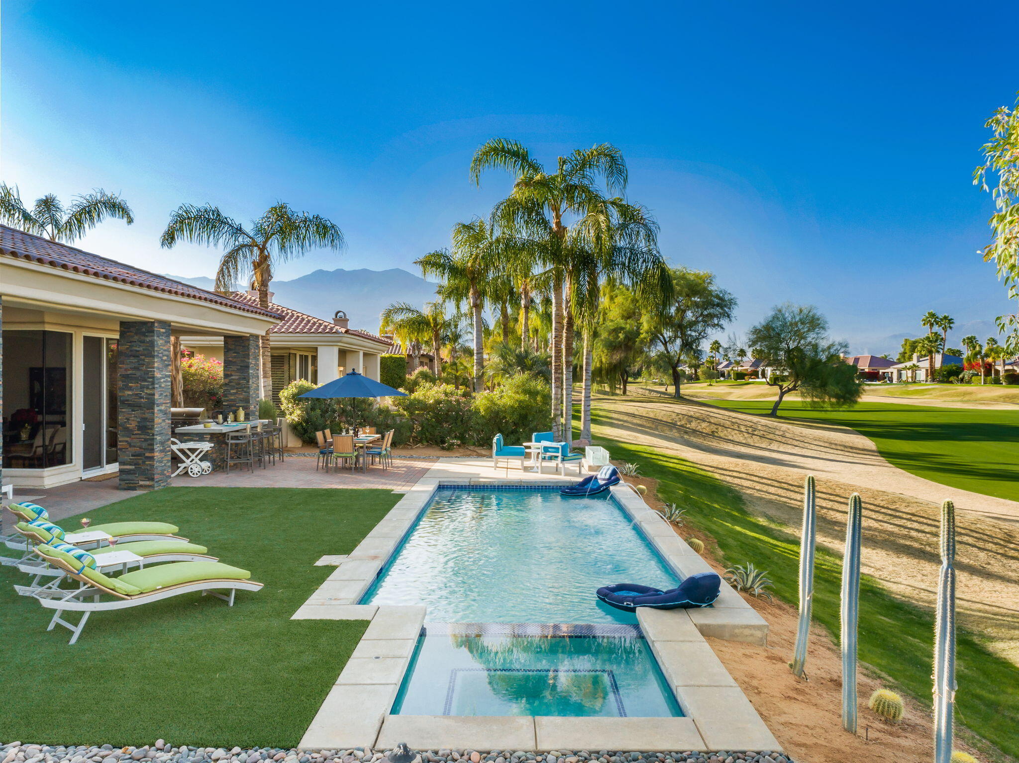 253 Loch Lomond Road Rancho Mirage, CA 92270 - Photo 65 of 66 a view of a house with swimming pool lawn chairs and a yard