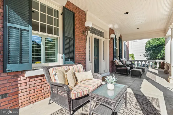 a living room with furniture a rug and a bookshelf