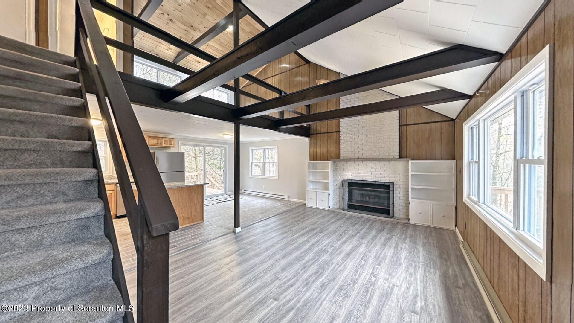 1013 Hemlock Way Newfoundland, PA 18445 - Photo 15 of 44 a view of empty room with wooden floor fireplace and windows