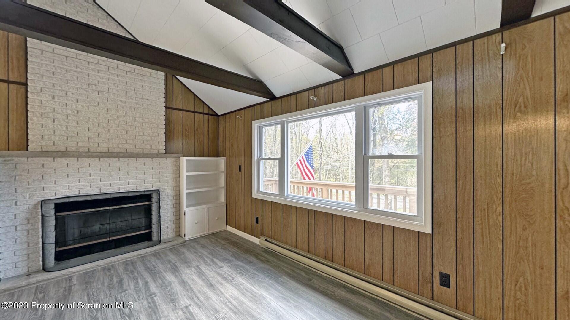 1013 Hemlock Way Newfoundland, PA 18445 - Photo 17 of 44 a view of an empty room with wooden floor fireplace and a window