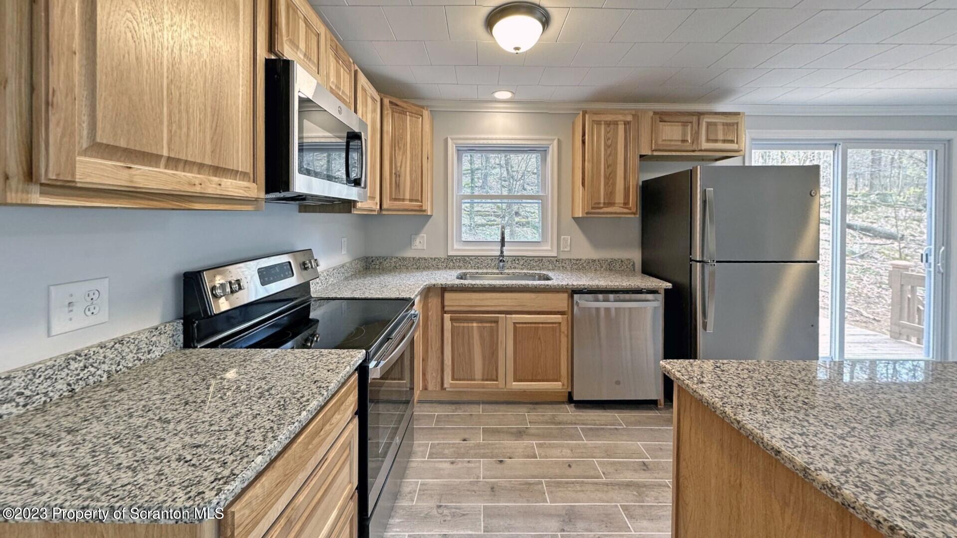 1013 Hemlock Way Newfoundland, PA 18445 - Photo 18 of 44 a kitchen with a stove a sink and a refrigerator