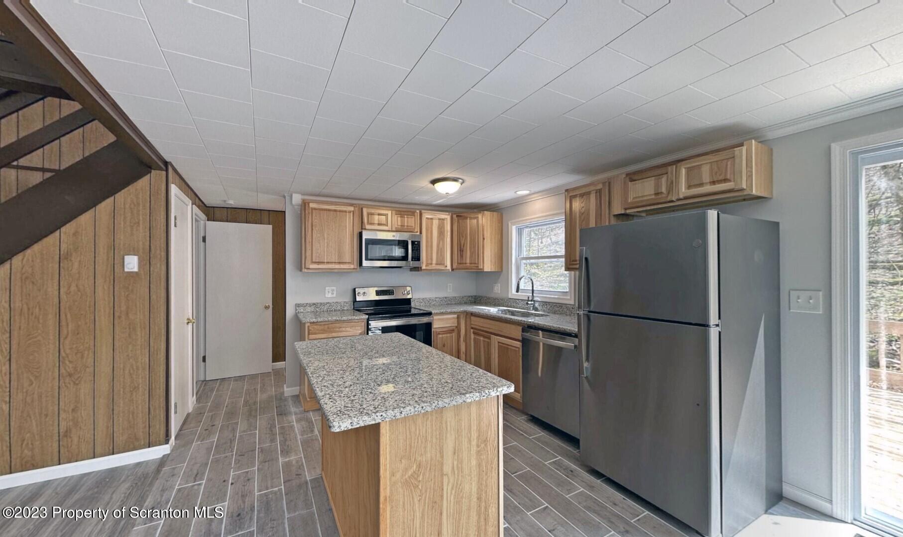 1013 Hemlock Way Newfoundland, PA 18445 - Photo 19 of 44 a kitchen with a refrigerator a microwave oven a sink and dishwasher