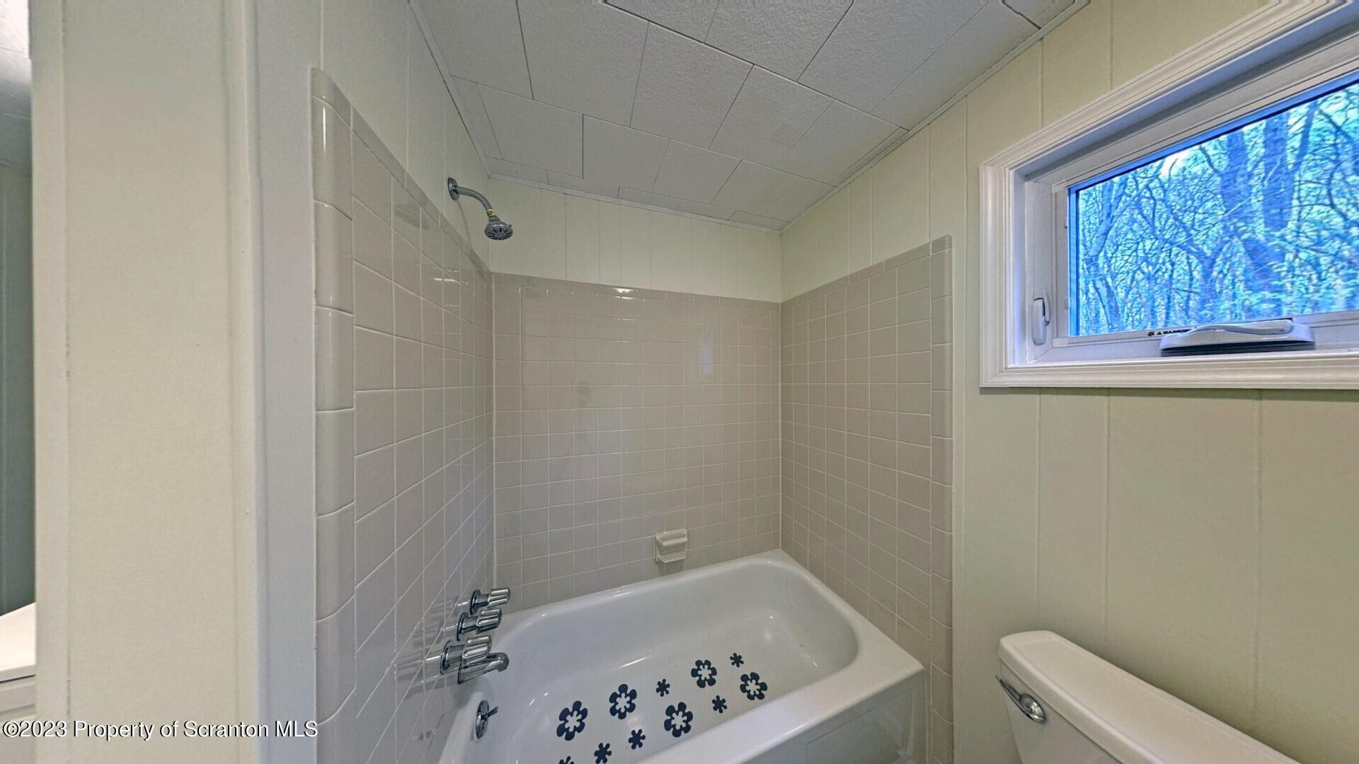 1013 Hemlock Way Newfoundland, PA 18445 - Photo 25 of 44 a bathroom with a bathtub and window