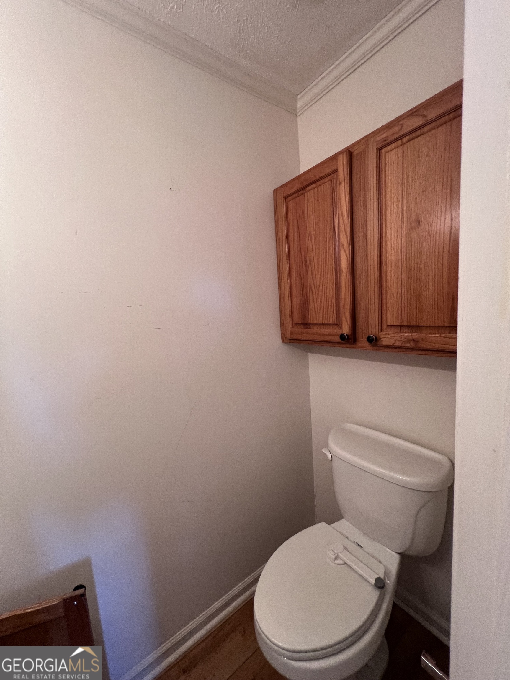 2205 Stonewall Street Dublin, GA 31021 - Photo 12 of 20 a white toilet sitting next to a wooden cabinet