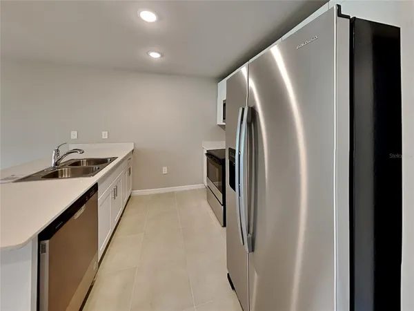 a kitchen with a refrigerator and a sink