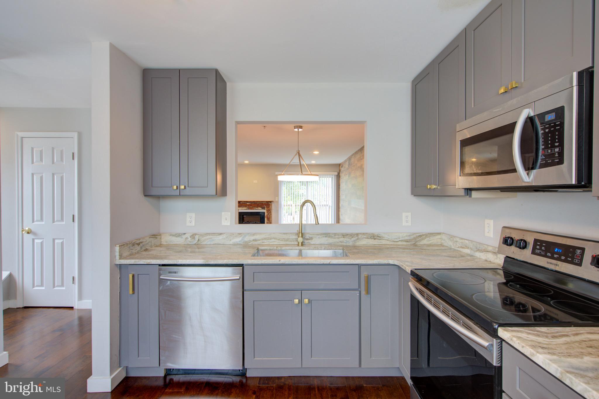 4304 Applegate Lane, Unit 2 Suitland, MD 20746 - Photo 12 of 27 a kitchen with stainless steel appliances granite countertop a sink stove and microwave