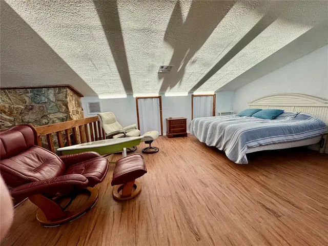 a living room with furniture a wooden floor and a large window