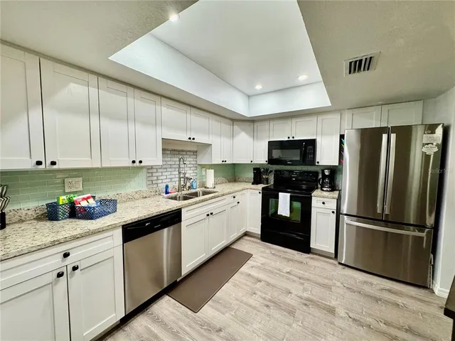 a living room with furniture a ceiling fan and a large window