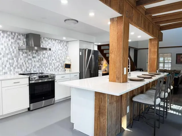 a kitchen with stainless steel appliances kitchen island granite countertop a stove a sink a refrigerator and island