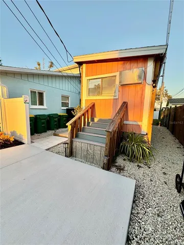 a bedroom with a bed a couch and potted plant on the dresser