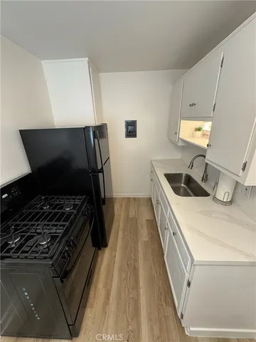a kitchen with granite countertop white cabinets and white appliances