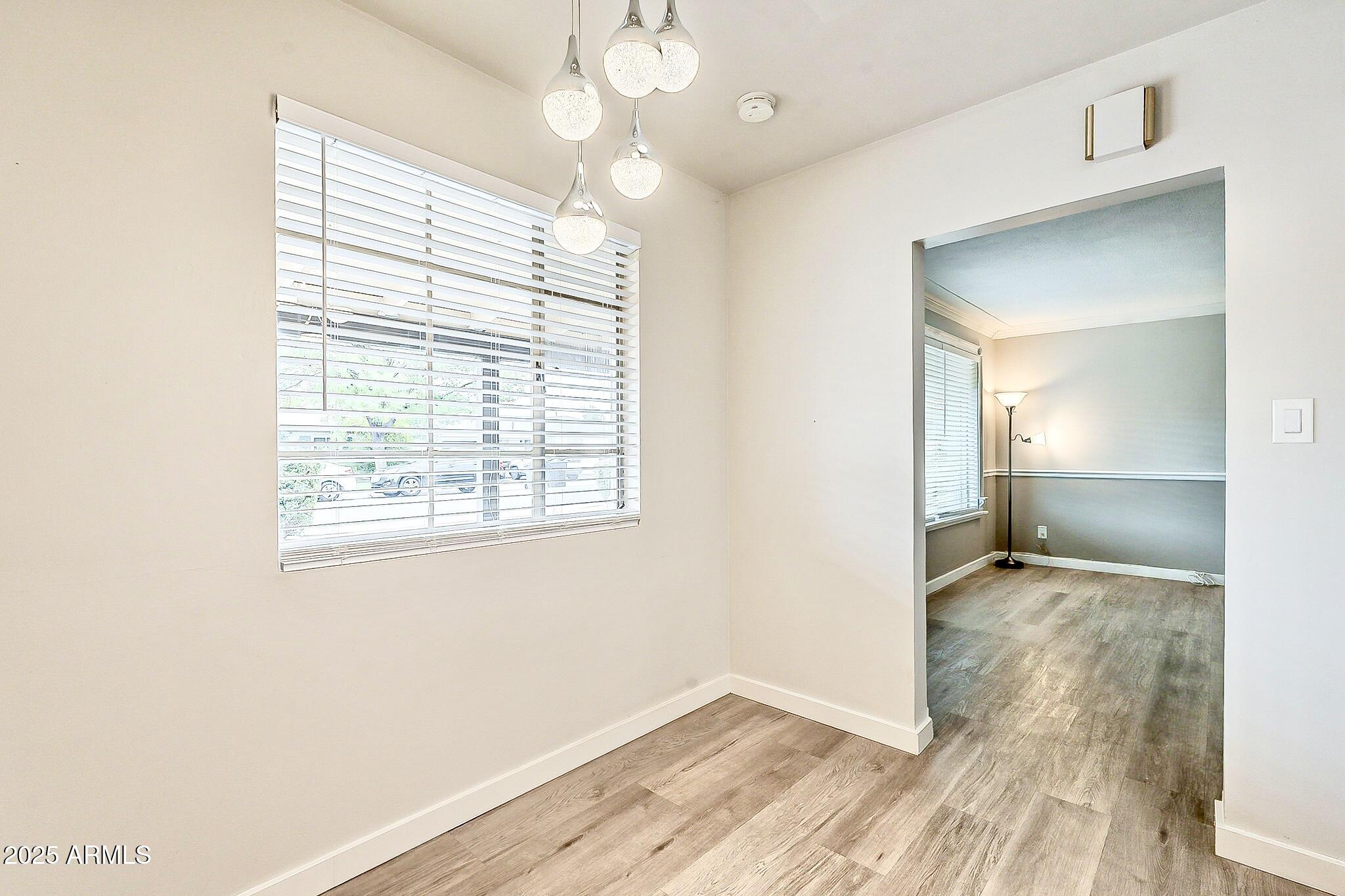 2150 West State Avenue Phoenix, AZ 85021 - Photo 12 of 32 a view of an empty room with wooden floor and a window