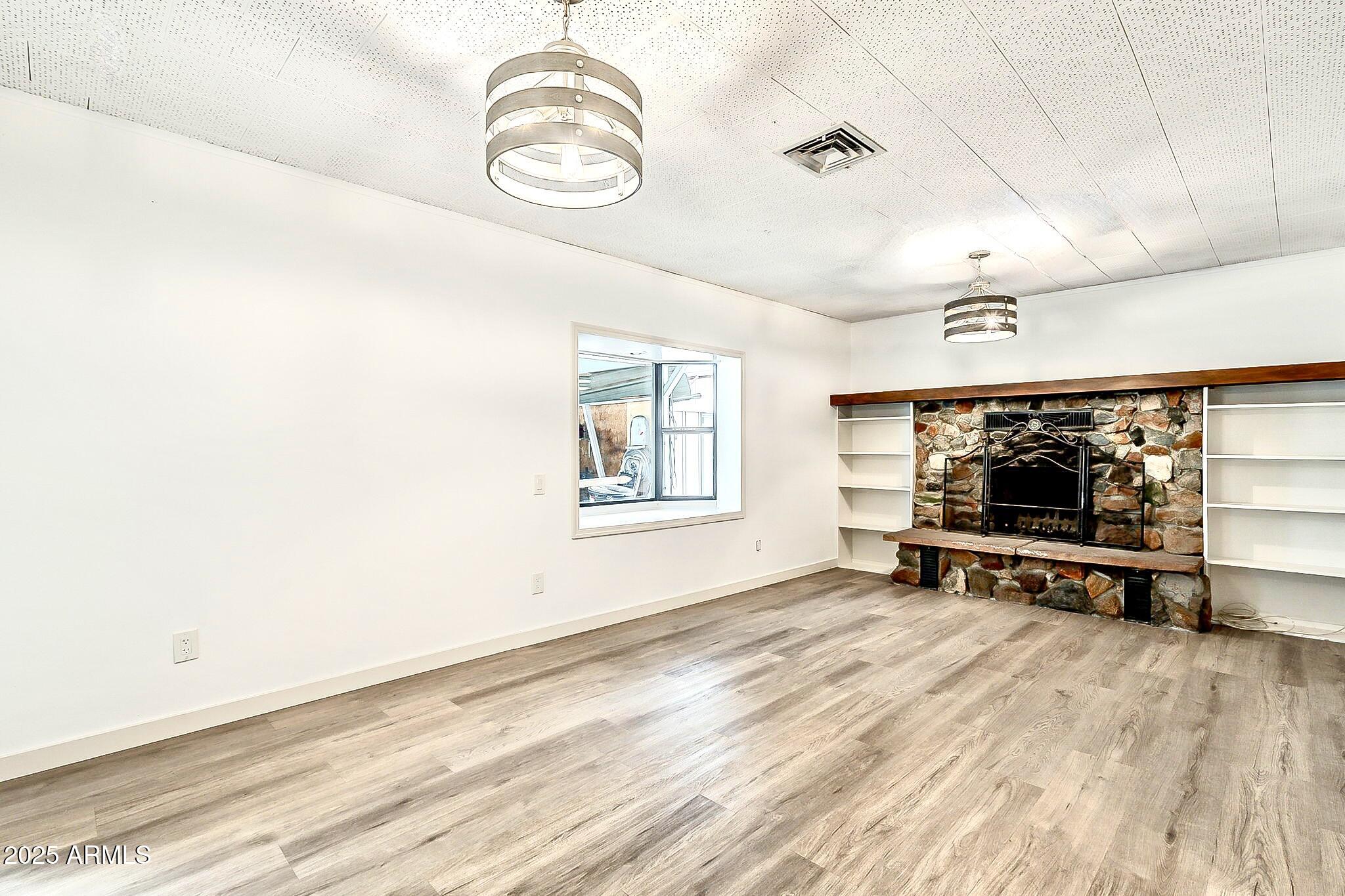2150 West State Avenue Phoenix, AZ 85021 - Photo 14 of 32 an empty room with windows and wooden floor