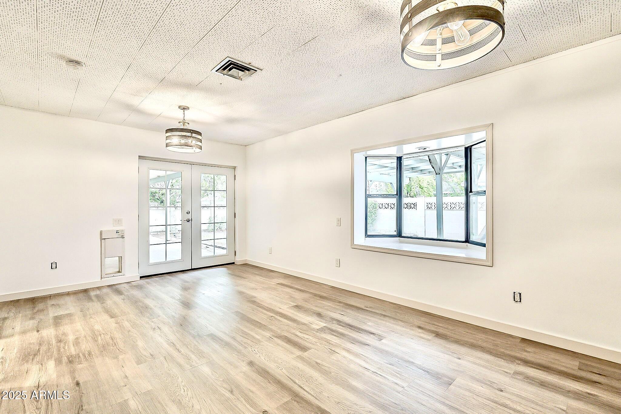 2150 West State Avenue Phoenix, AZ 85021 - Photo 15 of 32 an empty room with wooden floor and windows