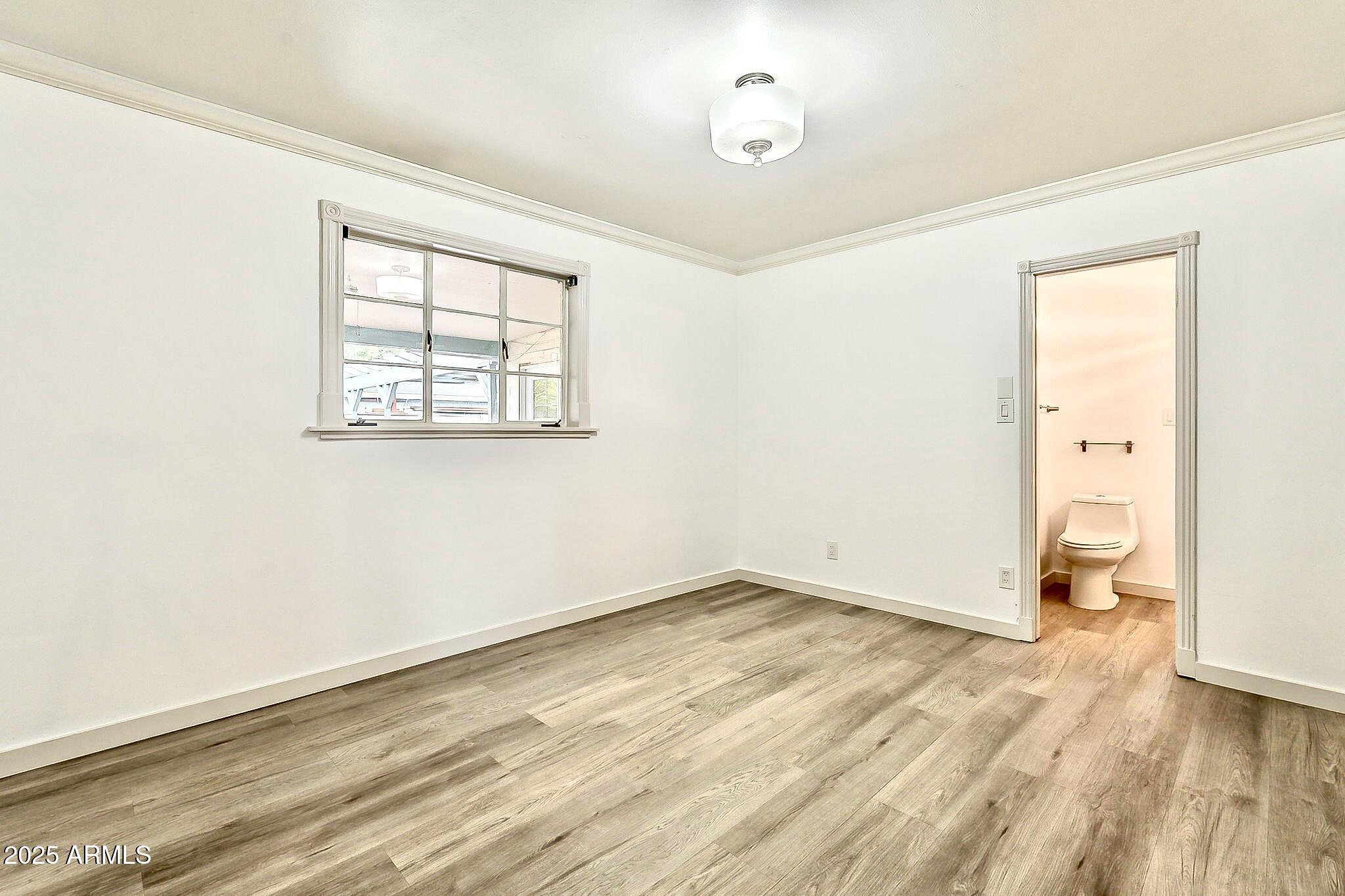 2150 West State Avenue Phoenix, AZ 85021 - Photo 18 of 32 an empty room with wooden floor and windows