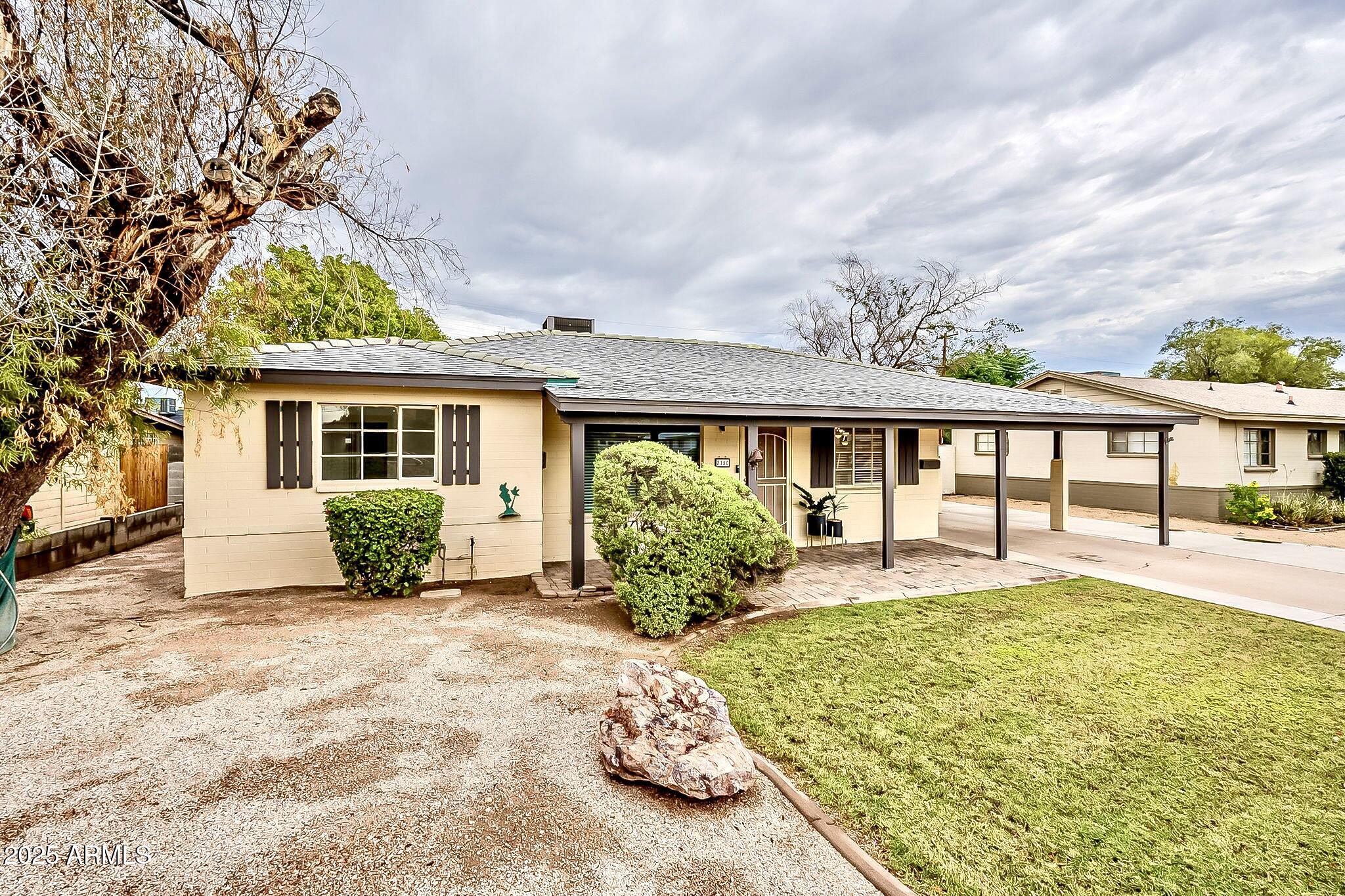 2150 West State Avenue Phoenix, AZ 85021 - Photo 2 of 32 a front view of a house with a garden and porch