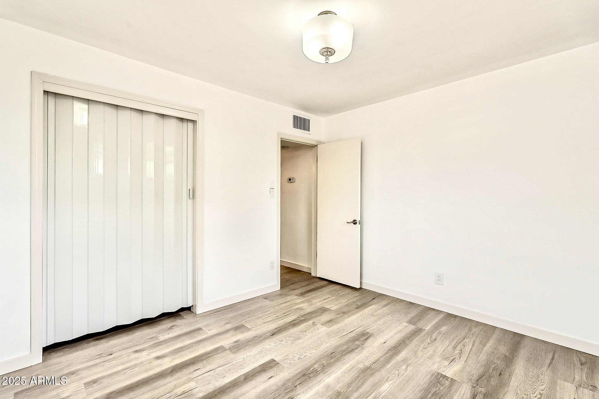2150 West State Avenue Phoenix, AZ 85021 - Photo 22 of 32 a view of an empty room with wooden floor