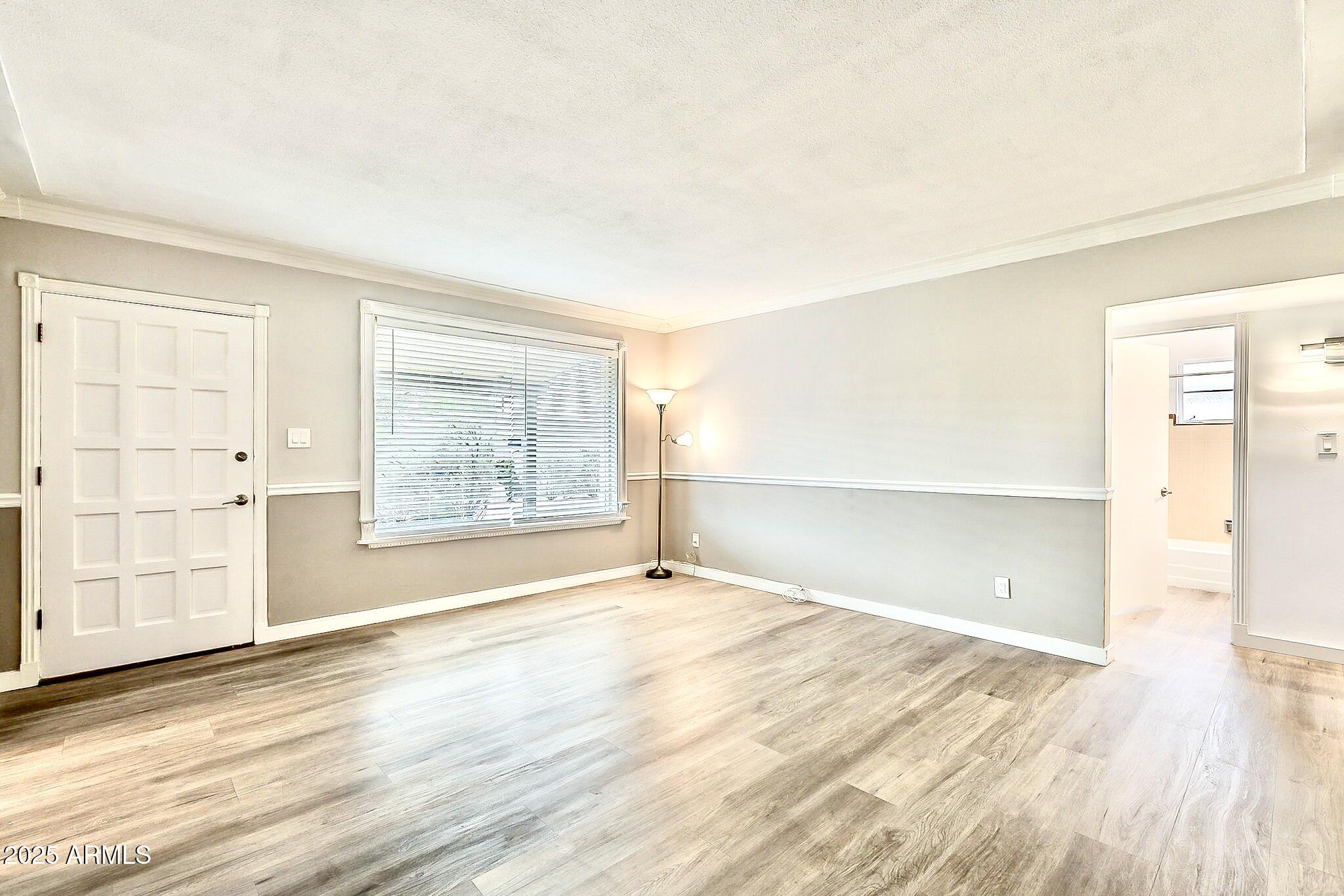 2150 West State Avenue Phoenix, AZ 85021 - Photo 6 of 32 an empty room with wooden floor and windows