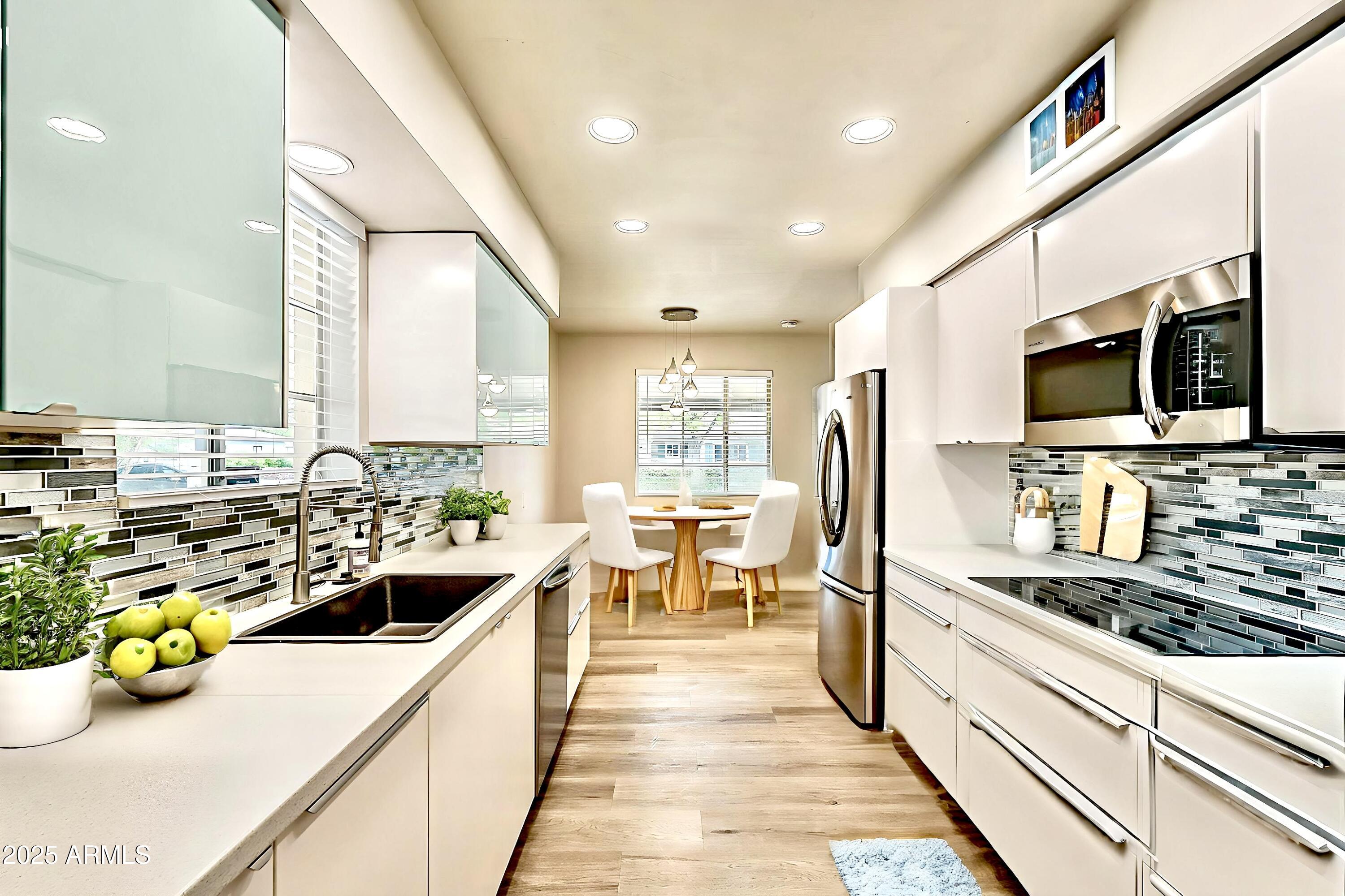 2150 West State Avenue Phoenix, AZ 85021 - Photo 7 of 32 a kitchen with sink a counter and chairs