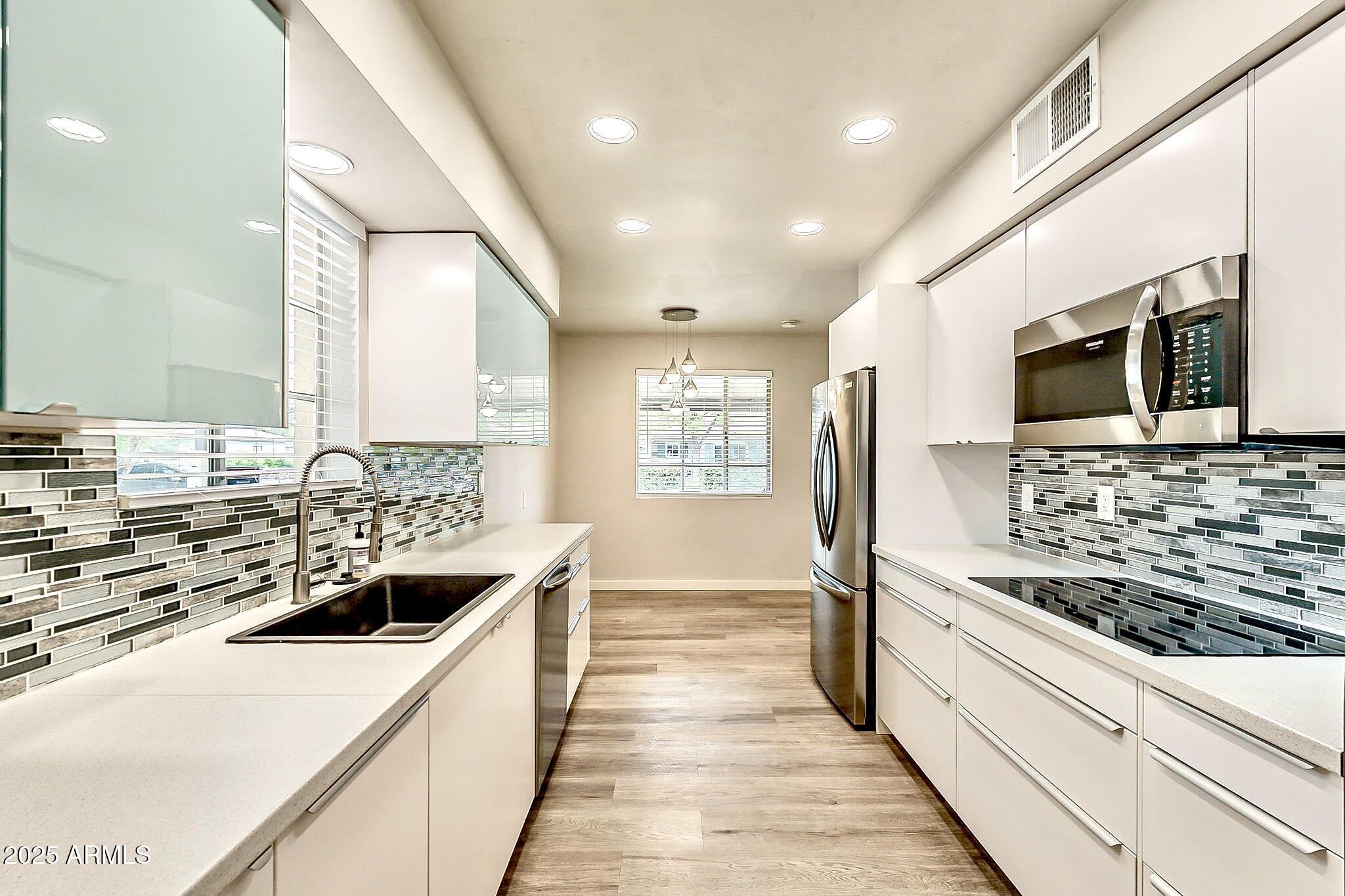 2150 West State Avenue Phoenix, AZ 85021 - Photo 8 of 32 a kitchen with stainless steel appliances kitchen island granite countertop a sink stove and refrigerator