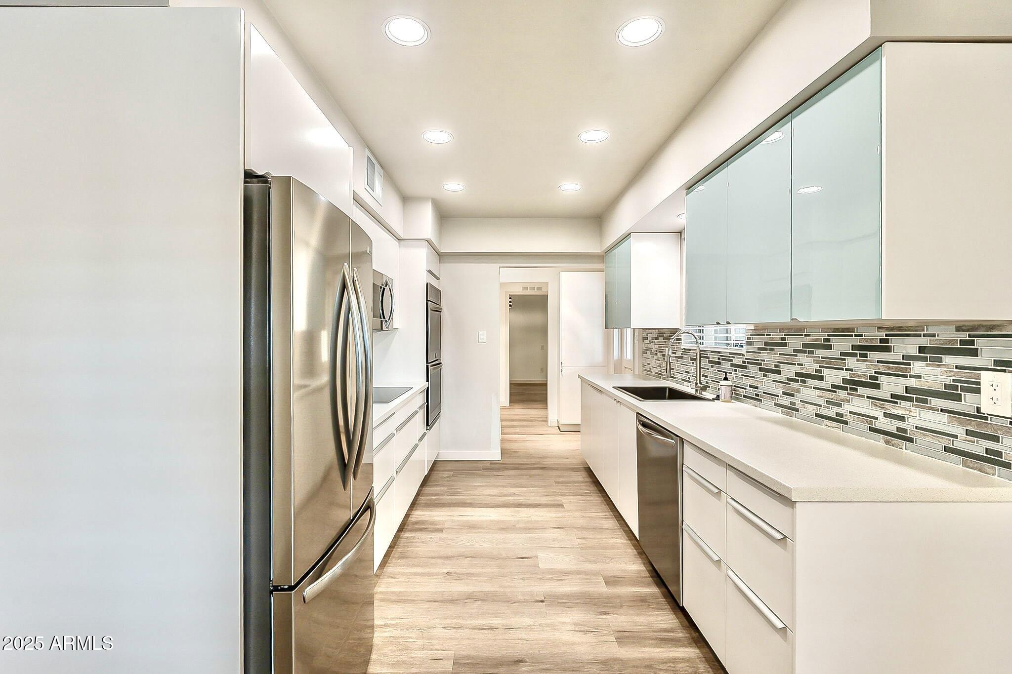 2150 West State Avenue Phoenix, AZ 85021 - Photo 9 of 32 a kitchen with stainless steel appliances granite countertop a stove and a refrigerator