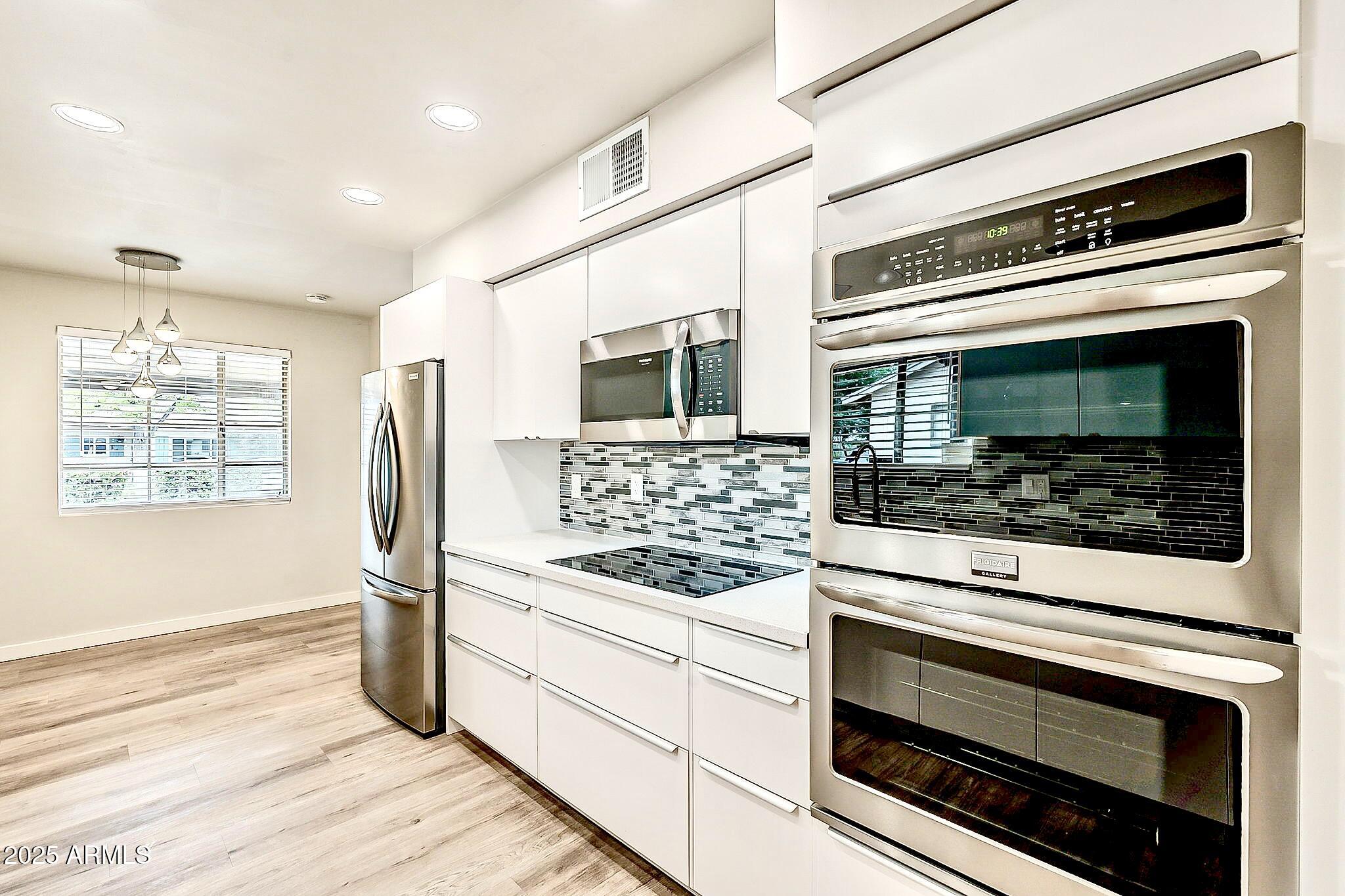 2150 West State Avenue Phoenix, AZ 85021 - Photo 10 of 32 a kitchen with white cabinets and appliances