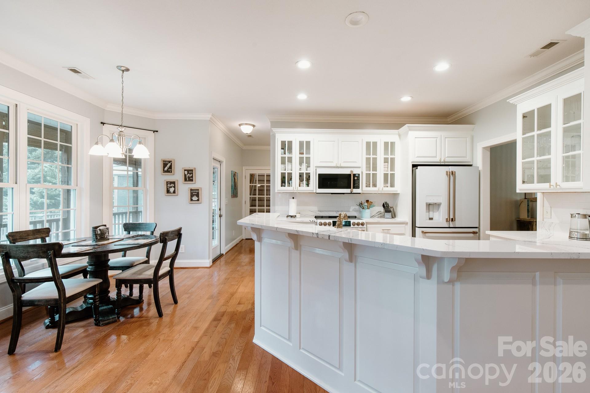 110 Mandy Lane Tryon, NC 28782 - Photo 16 of 48 a kitchen with stainless steel appliances granite countertop a stove top oven a sink dishwasher a dining table and chairs with wooden floor