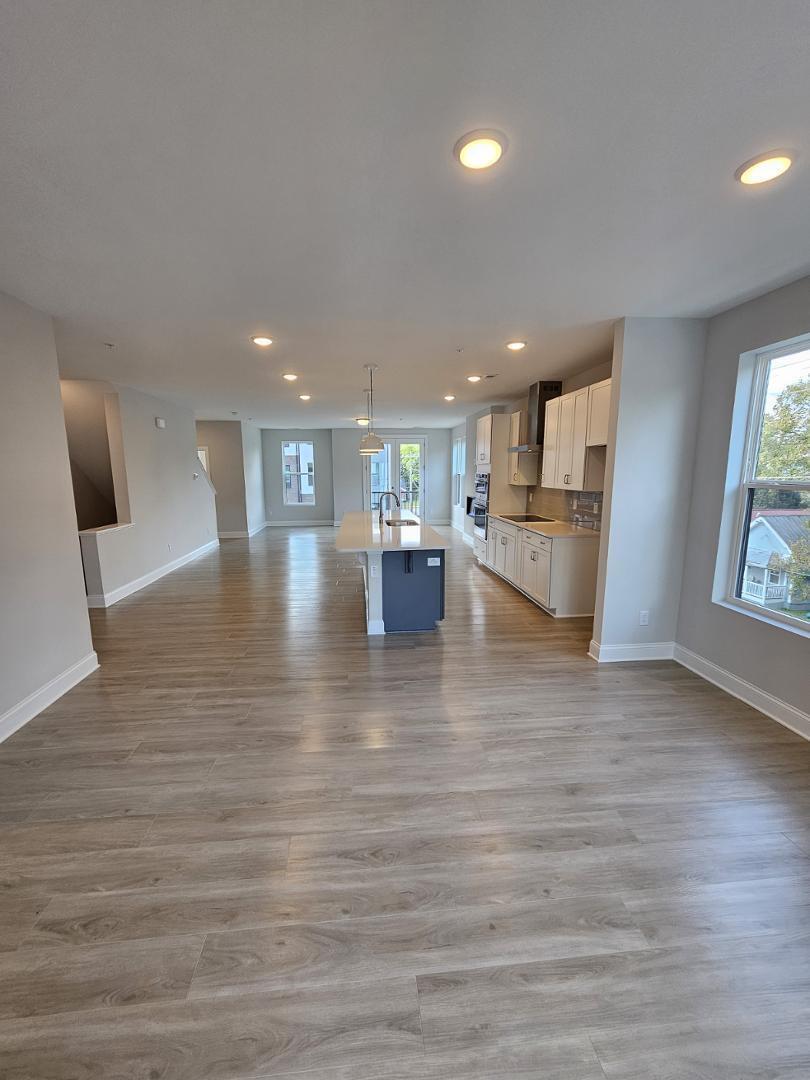 1202 Coach Station Alley, Unit 201 Raleigh, NC 27601 - Photo 5 of 16 a view of a living room kitchen and a wooden floor