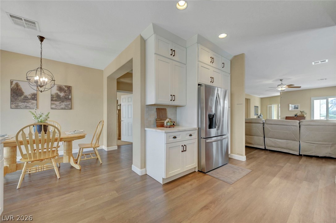 2700 Rue Montpellier Avenue Henderson, NV 89044 - Photo 37 of 39 Kitchen featuring open floor plan, stainless steel fridge with ice dispenser, light countertops, a chandelier, and light wood-style floors