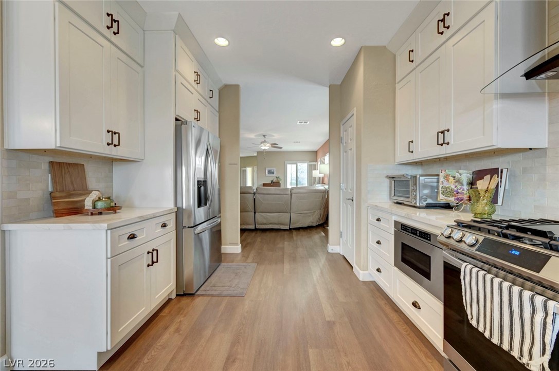 2700 Rue Montpellier Avenue Henderson, NV 89044 - Photo 39 of 39 Kitchen featuring backsplash, open floor plan, white cabinets, and recessed lighting