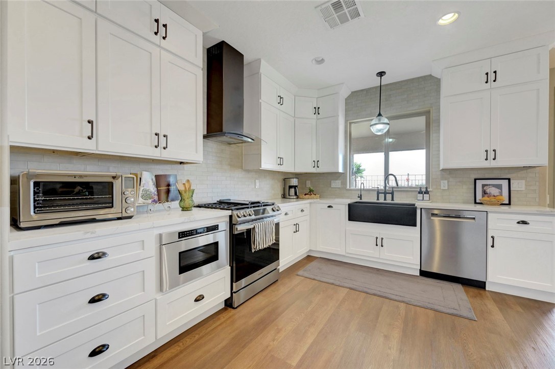 2700 Rue Montpellier Avenue Henderson, NV 89044 - Photo 3 of 39 Kitchen with white cabinets, stainless steel appliances, and light wood-style floors