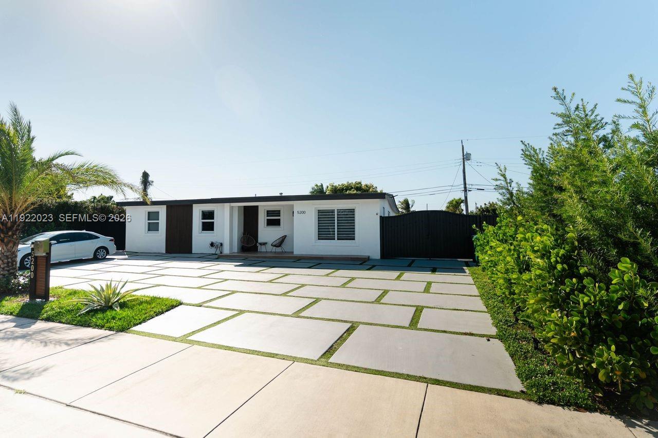 5200 Southwest 114th Court Miami, FL 33165 - Photo 3 of 36 a front view of a house with a garden