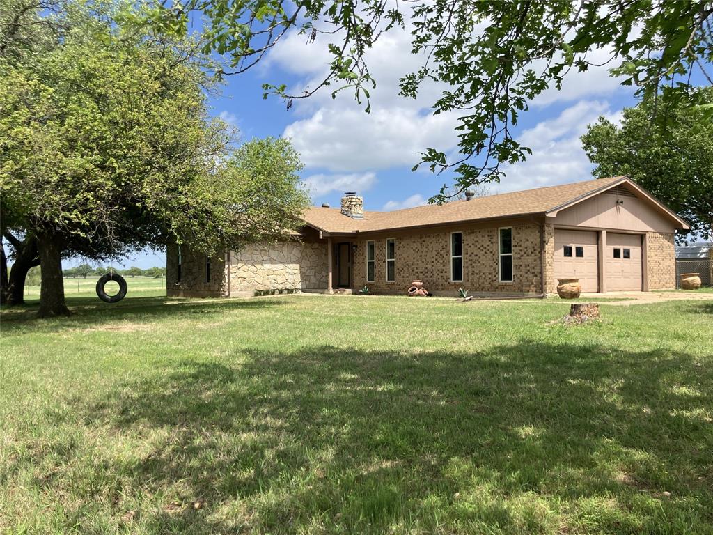 825 County Road 484 Ranger, TX 76470 - Photo 1 of 1 a front view of a house with a garden and trees