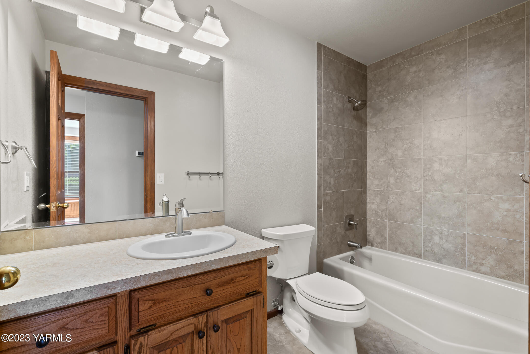291 Orchard Street Yakima, WA 98908 - Photo 16 of 35 a bathroom with a granite countertop sink a toilet a mirror and shower