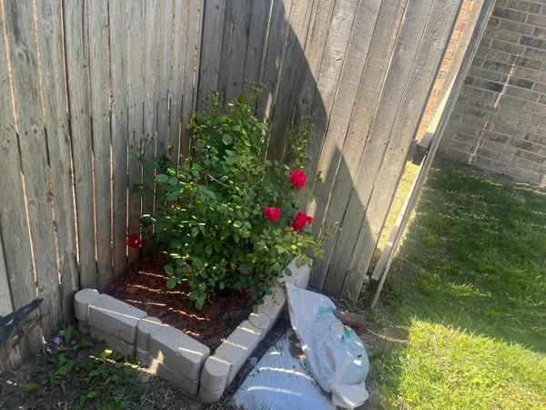 a wooden bench sitting in backside of a house with potted plants