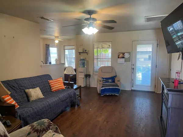 a living room with furniture and wooden floor