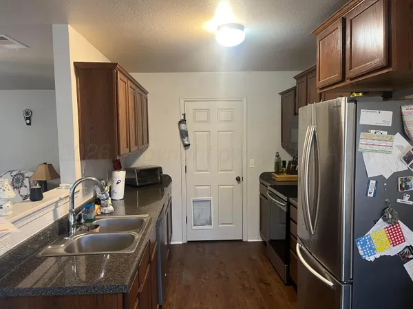 a kitchen with stainless steel appliances granite countertop a refrigerator and a sink