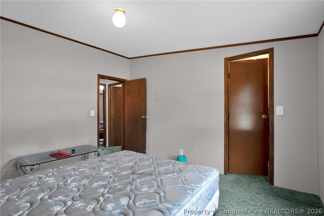 4705 Hickory Ridge Road Parkton, NC 28371 - Photo 25 of 37 a bedroom with a bed and a painting on the wall