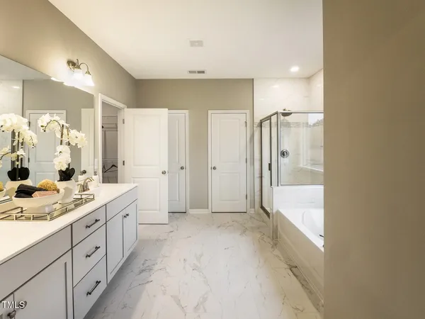 a spacious bathroom with a mirror a double vanity sink and shower