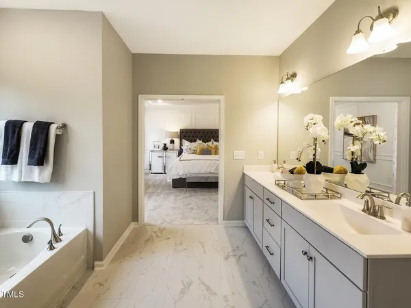 a en suite bathroom with a double vanity sink and mirror