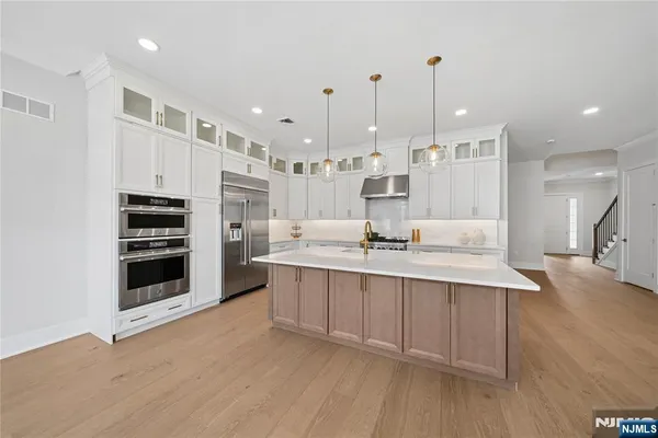 a large kitchen with kitchen island a sink stainless steel appliances and cabinets