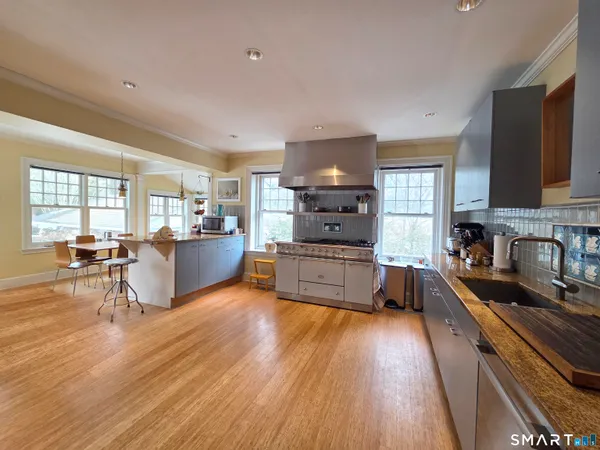 a kitchen with stainless steel appliances wooden floors stove and sink