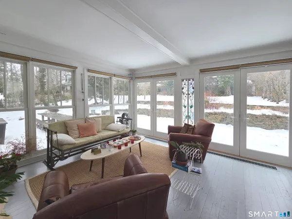 a living room with furniture and floor to ceiling windows