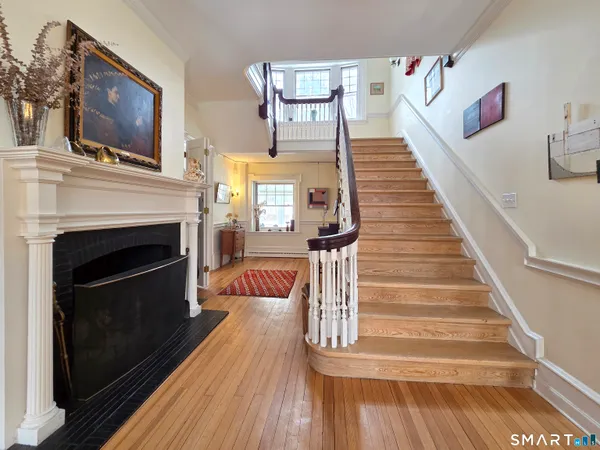 a view of a livingroom with wooden floor and a fireplace